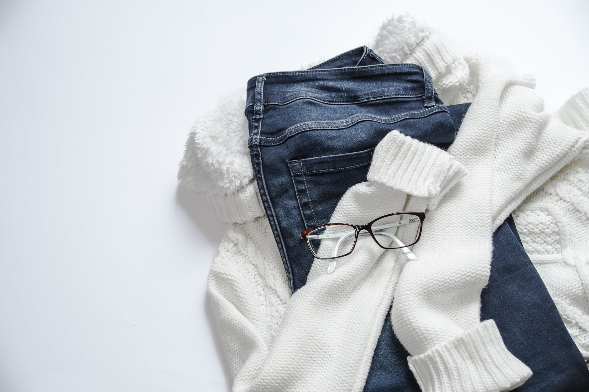 black framed eyeglasses on white jacket and blue denim bottoms