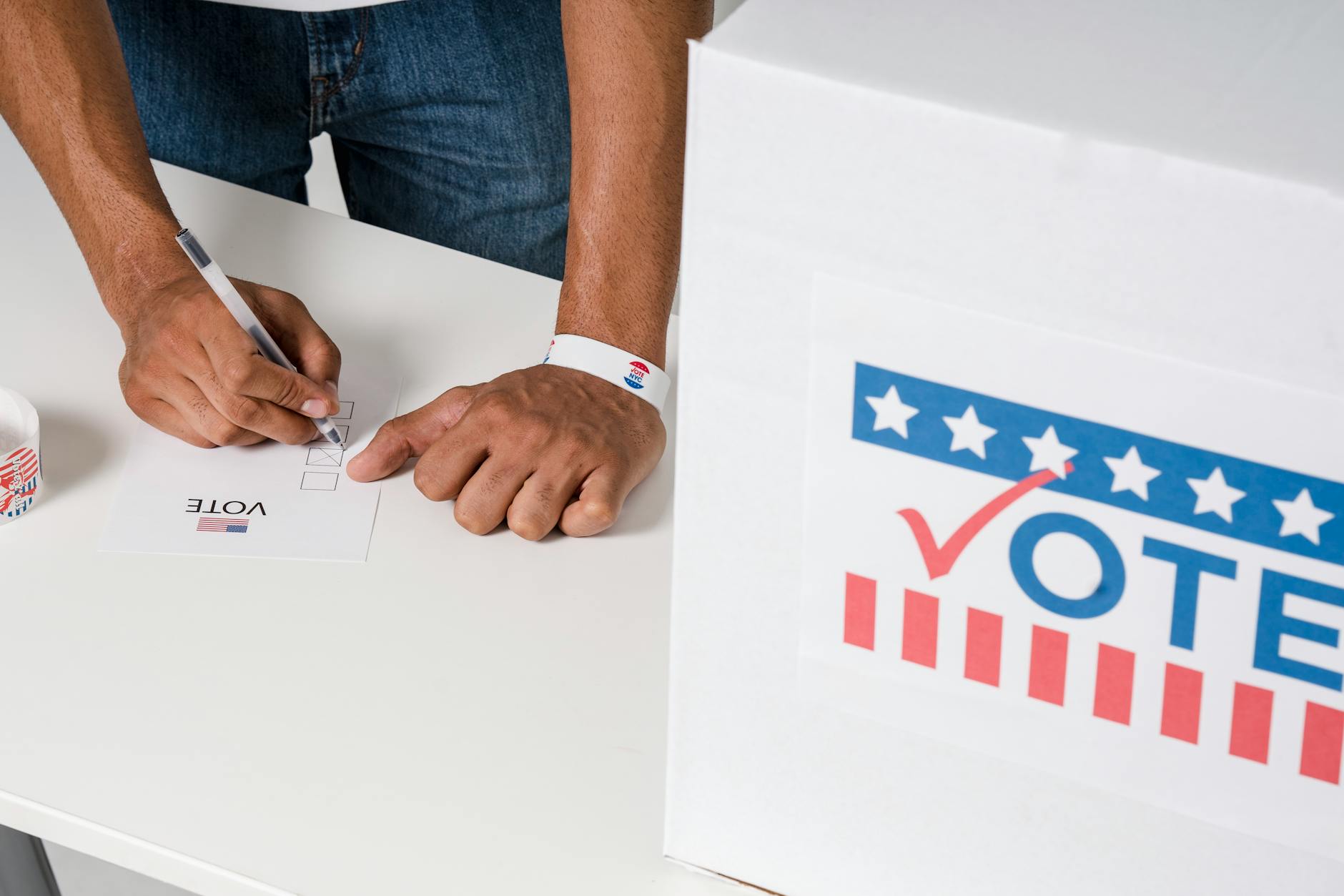 a person with a wristband casting a vote