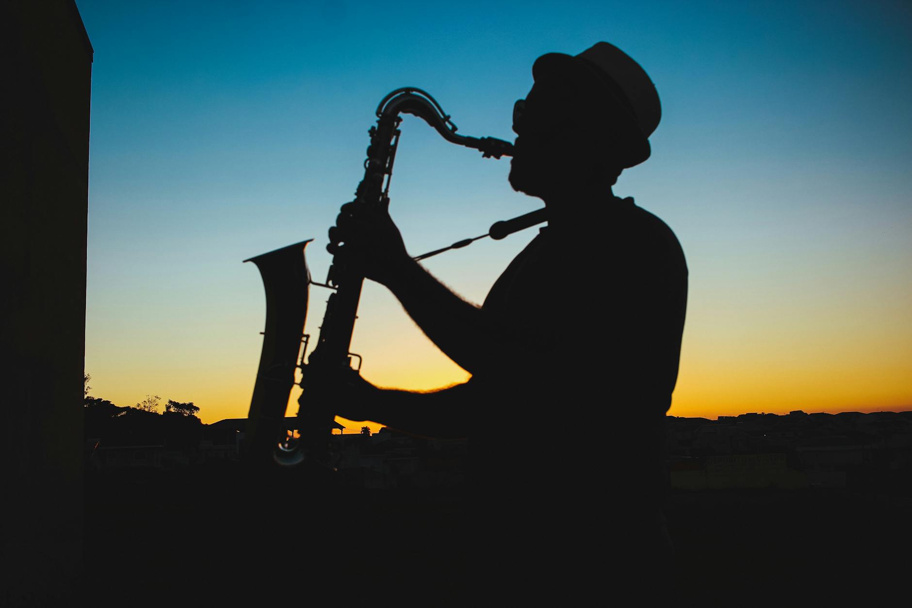 silhouette of a man playing saxophone during sunset